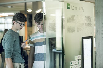 Twee jongeren bekijken de console Communit van de tentoonstelling Conn3ct
