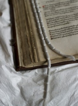 Boek op een kussen met een loodlint