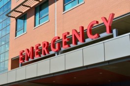 Het woord 'emergency' in rode letters op een gevel