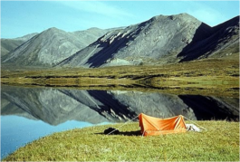 Foto van een tentje nabij een meer in een berglandschap