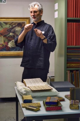 Bibliothecaris toont historische boeken op een tafel
