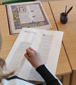 Kind maakt bladspiegel aan de hand van voorbeeld middeleeuws manuscript