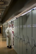 Pater bij compacusrekken in bibliotheekmagazijn