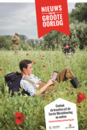 Soldaat leest krant op ipad in een klaverveld