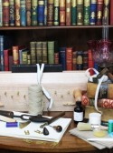 Boekenkast met tafel met boekbindersmaterialen ervoor