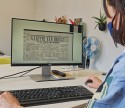 Vrouw bekijkt digitale krant op computer