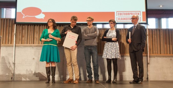 Het team en de voorzitter van de Vlaamse Erfgoedbibliotheek op het podium tijdens de prijsuitreiking